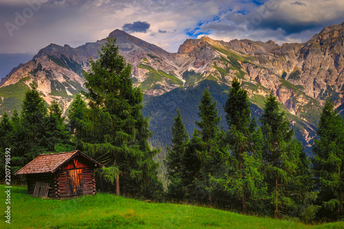 Alpine cabin beneath a dramatic mountain range