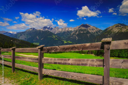 Alpine mountain panorama behind a rustic wooden fence