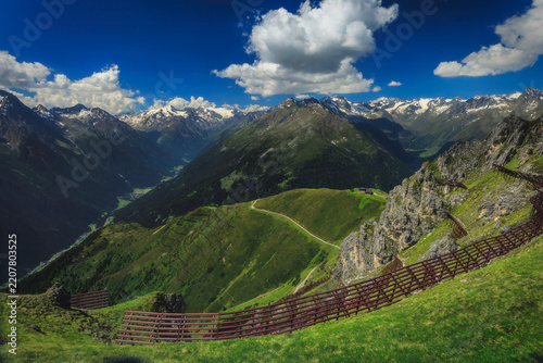 Alpine mountain valley beneath a dramatic sky