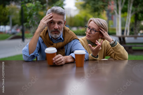 Mature couple having serious relationship discussion outdoors