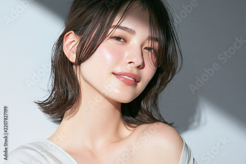 強い光と陰影の中で艶のある素肌と黒髪を見せる日本人女性の美容広告ポートレート