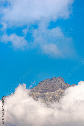 Coca peak above the clouds, Bergamo Alps, Italy landscape
