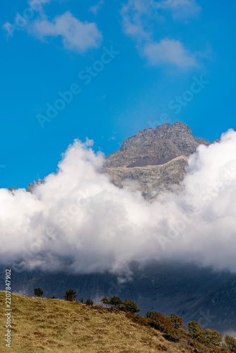 Coca peak above the clouds at sunset, Bergamo Alps, Italy landscape