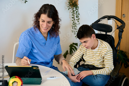 Nurse performing home healthcare check up for boy with cerebral palsy