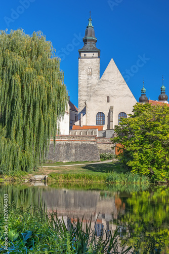 View of St. James Church in Telc across pond with reflections. Czech Republic. Vertically. 