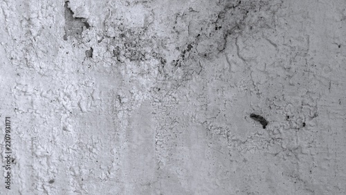 Fotografie Monochrome aged plaster wall with peeling paint, rough patches, scratches and dark exposed areas, creating a natural grunge texture for design use