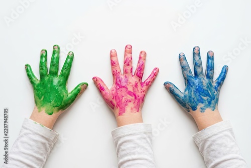 Three hands painted in vibrant green, pink, and blue colors are displayed against a white background.