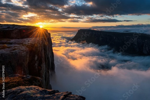 Sunrise over fjord cliffs above cloud sea in Norway, golden morning light and dramatic sky