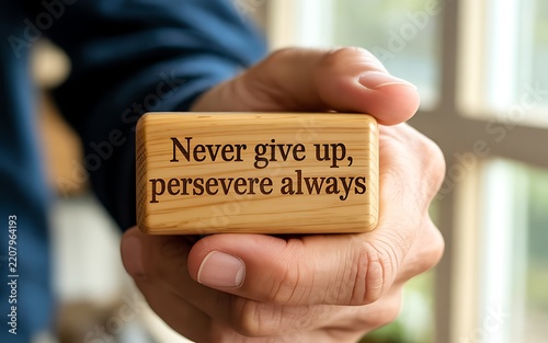 Hand holding wooden block quote never give up persevere always motivational message image