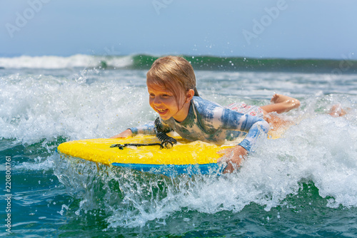 Obraz na plátně Happy young surfer girl with bodyboard have fun on beach, riding on small ocean waves