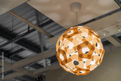 Modern spherical pendant light with a geometric patterned shade hanging from the ceiling in a contemporary industrial style interior.