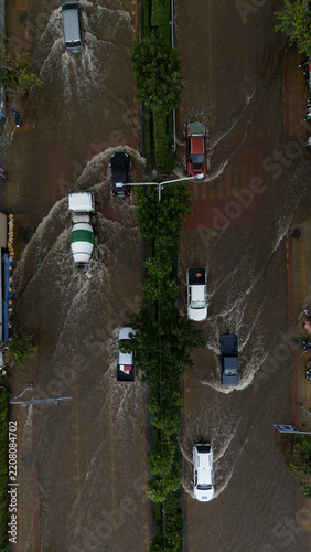 An elevated view of a flooded road with vehicles driving through the water.