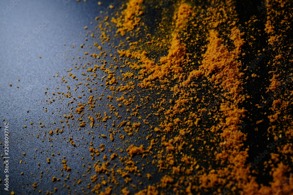 Fototapeta premium Curry Powder Lines on Black Textured Background with Copy Space