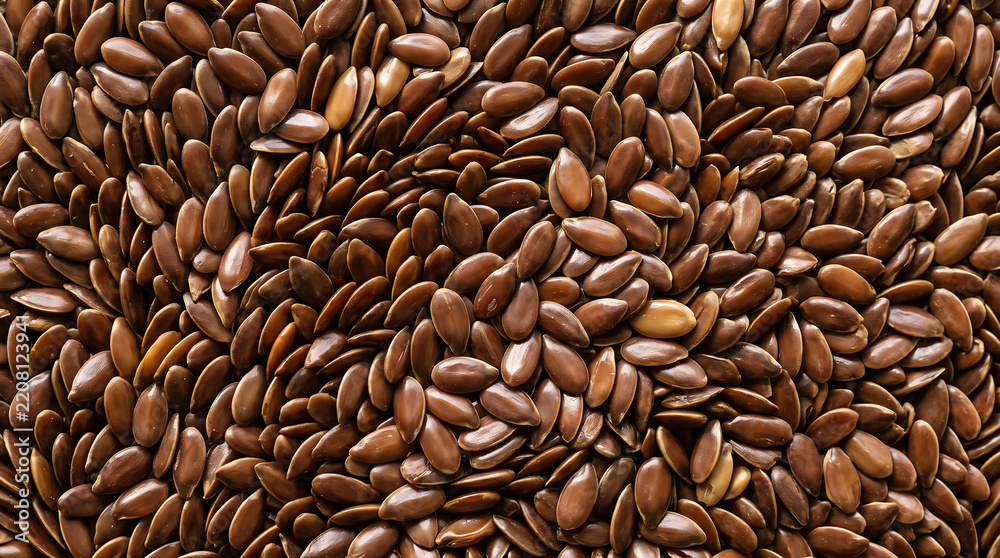 Obraz premium Close up view of whole flaxseeds spread out naturally in rich brown color