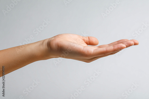 Close-up of an outstretched hand on a white background palm up with space for product presentation
