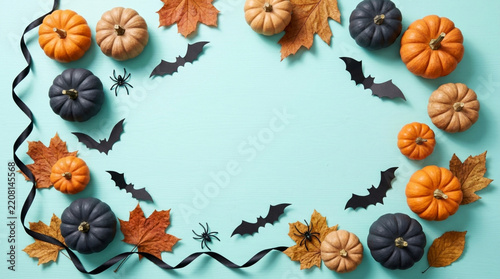 Halloween festive frame with pumpkins, bats, spiders and autumn leaves on blue