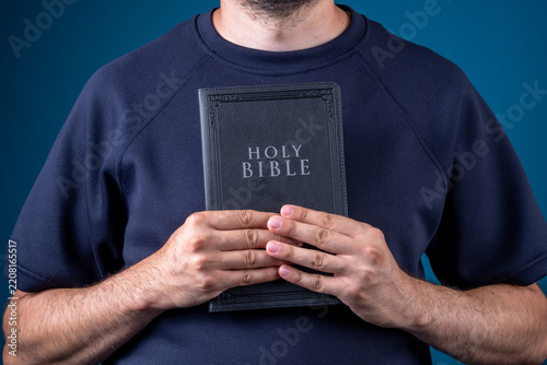 Fotografie A person holds the Holy Scripture in their hands.