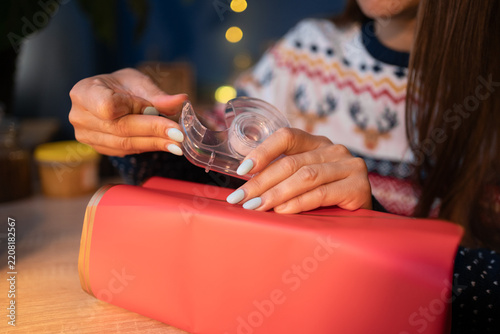 Close Up of Female Hands Wrapping Red Box with Adhesive Tape