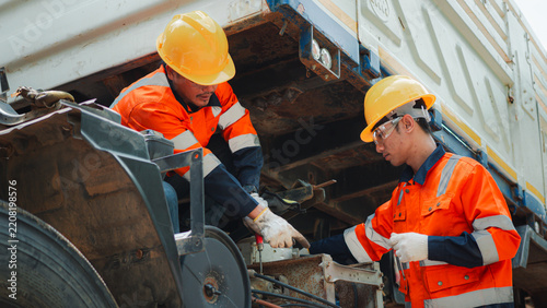 Two Male Mechanics Working Together Repairing Commercial Truck Engine Maintenance