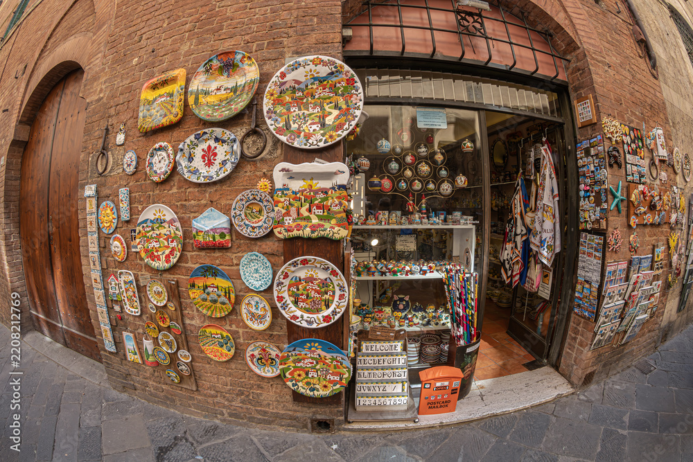 Obraz premium Siena, Tuscany, Italy - May 23, 2026: The facade of a traditional shop selling handicrafts, ceramics and souvenirs, in the historic center. 