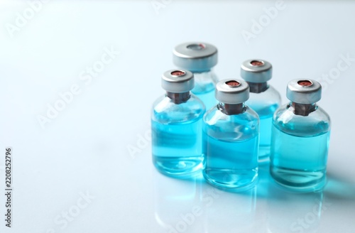 Small bottles with a blue liquid. Examples of vaccines and other medical equipment. Copy space