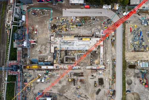 Aerial view of the construction site at Heizkraftwerk Reuter West power plant with a large red tower crane, excavation work, and industrial machinery in Berlin, Berlin, Germany.