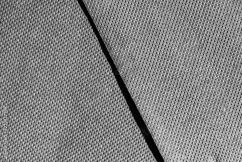 Grey fabric textile material texture background with diagonal seam line