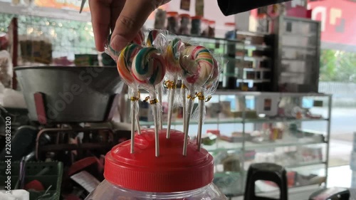 Hand Arranging Colorful Lollipops on Display