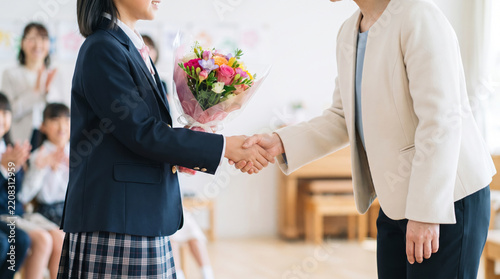 Obraz na płótnie 卒業式で花束を持ち先生と握手する女子生徒