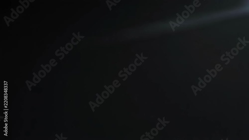 Cinematic Lens Flare Drifting Across Dark Background