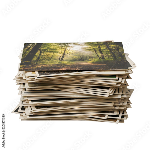 A large messy stack of printed paper photographs on white