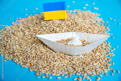 Ukrainian Grain Export Blockade and Food Crisis Concept with Paper Boat and Flag on Wheat Seeds Background