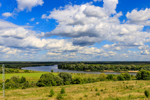 Panoramic view of river valley with scattered clouds and rolling hills