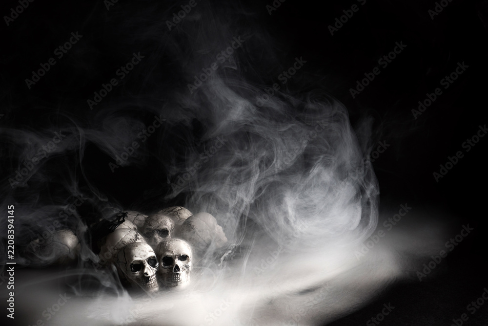 Fototapeta premium Human skulls emerging from mysterious smoky fog