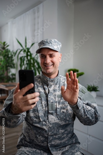 Smiling soldier making a video call with his family