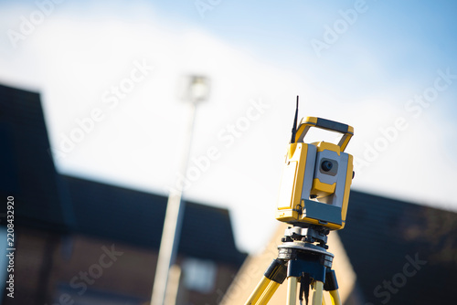 Surveying equipment set up on a construction site during the day under clear blue skies