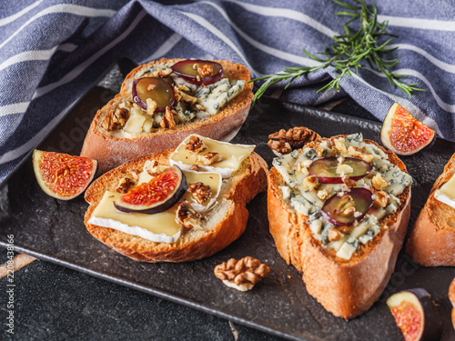Obraz na plátně Bruschetta with Gorgonzola, Brie, figs, grapes and walnuts