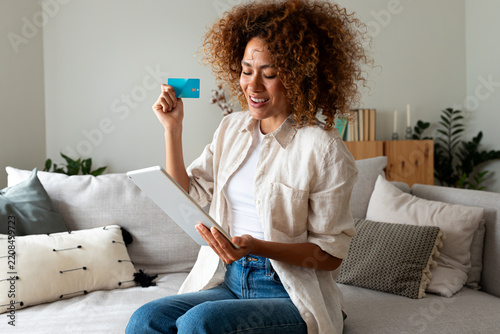 Woman online shopping using tablet, holding credit card