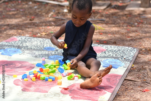 Little girl building colorful blocks tower outdoor play
