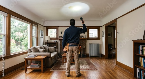 Home Inspection with Flashlight in Modern Living Room Setting.