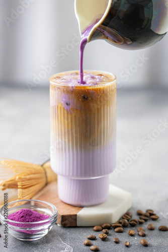 Ube latte with coffee in glass. Healthy vegan drink. Viral trendy asian beverage