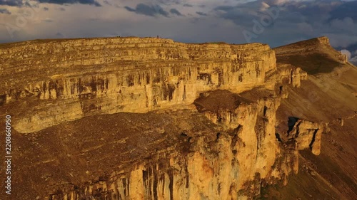 Aerial view of Bermamyt plateau with dramatic rocky cliffs illuminated by golden hour light in Malokarachayevsky District, Karachay-Cherkessia, Russia.