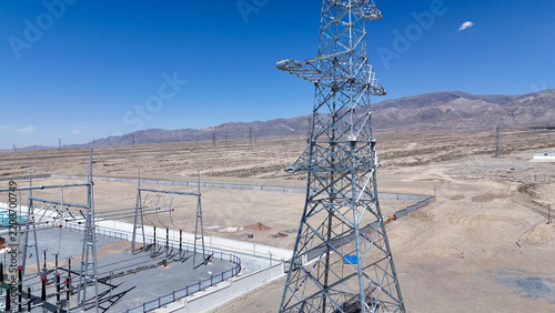 high voltage transmission tower and substation in desert landscape