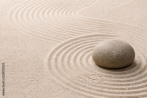 Single smooth stone on raked sand in a zen rock garden