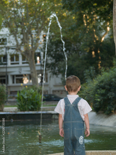 Child watching fountain in park