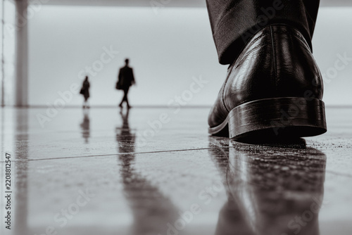 Close-up of a man's leather shoe walking on a polished floor