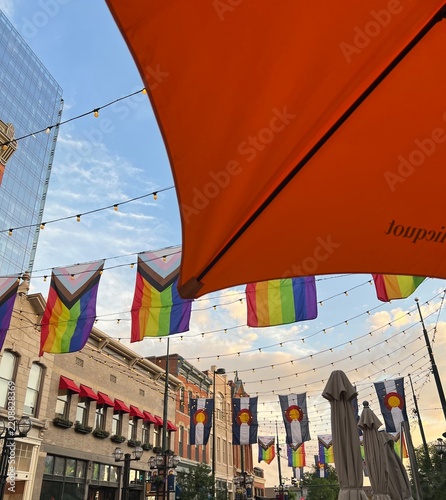 Outdoor City Street With Rainbow Pride Flags, Colorado Flags, String Lights and Orange Umbrellas