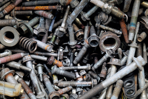Rusty metal bolts and screws creating industrial background
