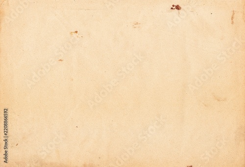 Aged, beige paper with uneven discoloration and scattered dark spots, conveying a nostalgic vintage feel suitable for backgrounds and creative projects