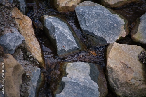 Dark water flows between mossy, jagged rocks